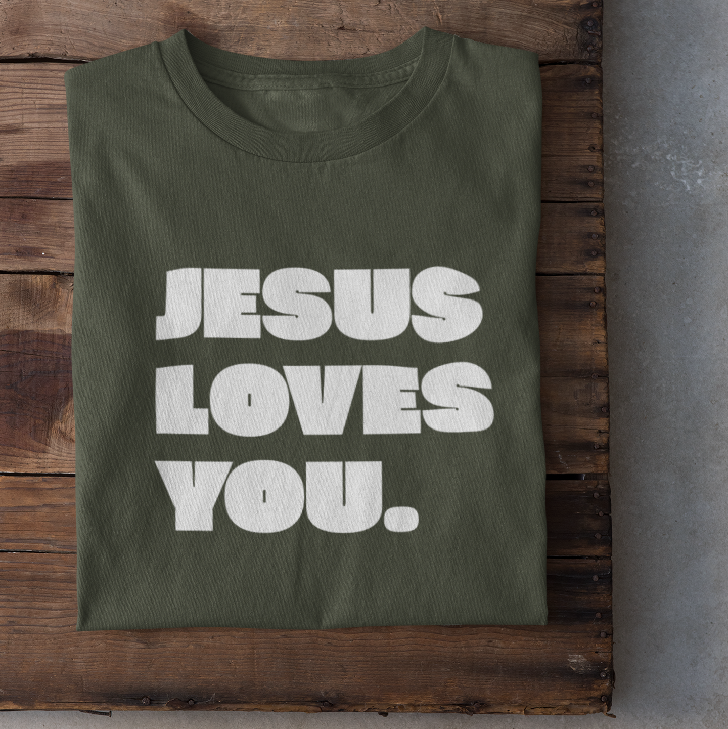 Ein kakifarbiges tshirt mit den Schriftzug Jesus loves you. in weiß darauf