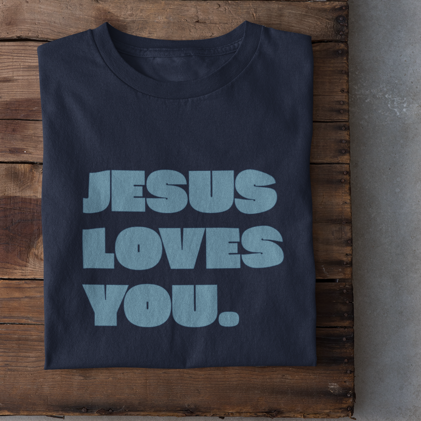 Ein navyfarbiges tshirt mit den Schriftzug Jesus loves you. in blau darauf