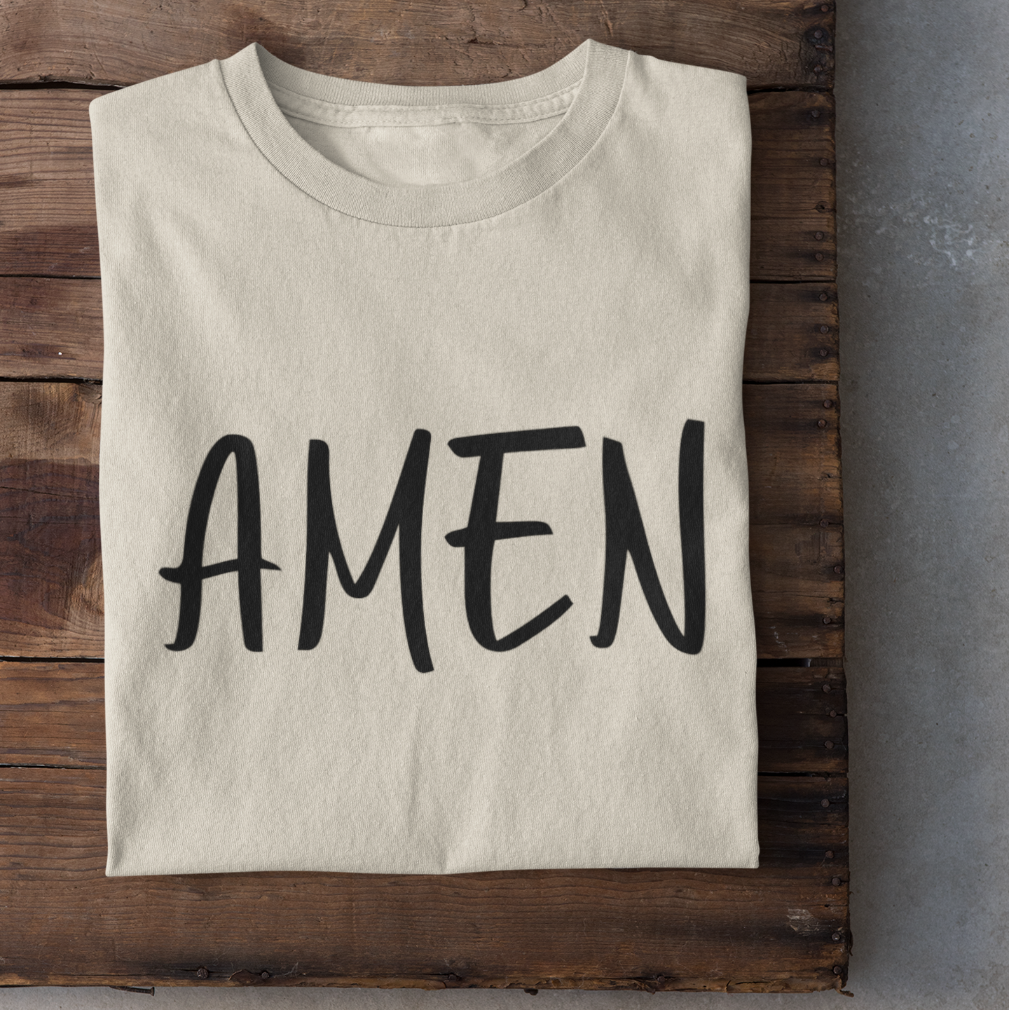Ein sandfarbiges tshirt mit den Schriftzug Amen in schwarz darauf
